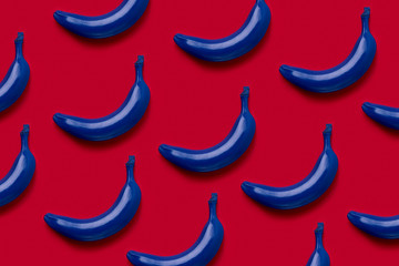 Colorful fruit pattern of fresh blue bananas on red background. From top view