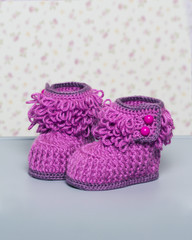 Glamour pink baby booties on grey background