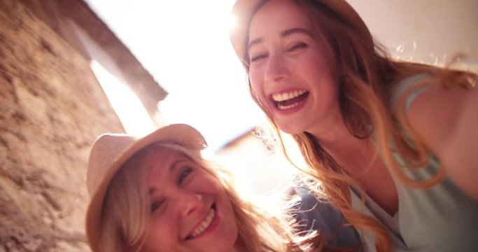 Beautiful grandmother and granddaughter taking funny selfies on European vacations