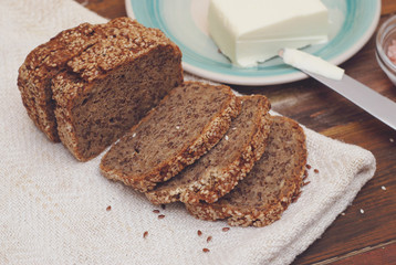 Whole Grain Bread with Seeds. Breakfast. fitness Diet Bread Sliced with Butter. Wooden board.