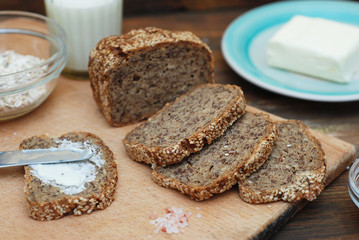 Whole Grain Bread with Seeds. Breakfast. fitness Diet Bread Sliced with Butter. Wooden board.