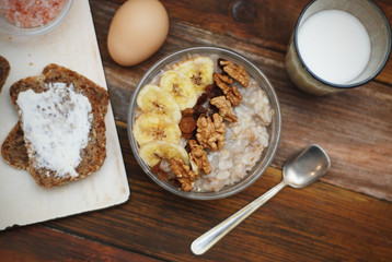 Breakfast with Granola Bowl, Muesli with Oats, Nuts and Dried Fruit, Milk, on Wooden table. Bannana, nuts, fruits. Healthy Breakfast. Diet.