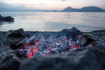 Smoldering ashes from a campfire next to Lake Koya in Hokkaido, Japan