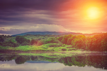 beautiful lake sunset, behind mountain forest