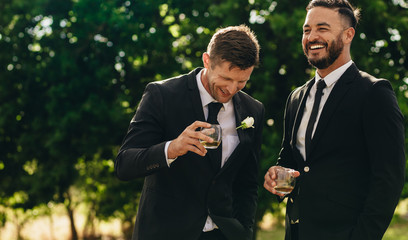 Groom and best man drinking at wedding party - Powered by Adobe