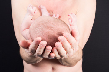 newborn baby in father hands