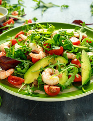 Fresh Avocado, shrimps salad with lettuce green mix, cherry tomatoes, herbs and olive oil, lemon dressing. healthy food