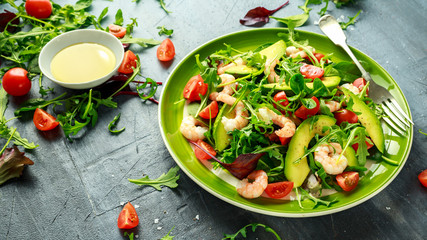 Fresh Avocado, shrimps salad with lettuce green mix, cherry tomatoes, herbs and olive oil, lemon dressing. healthy food