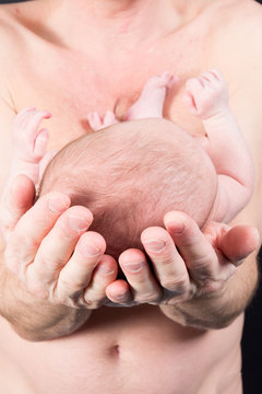 pround father holding in hands arm newborn baby infant