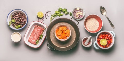 Bowls with ingredients for balanced one pan meal with beans, minced meat, rice and vegetables on gray background, top view, flat lay