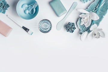 Blue Cosmetic setting for facial skin care with white orchid flowers, homemade mask tools and...