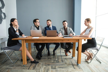 Meeting of a team of businessmen in a room for negotiations