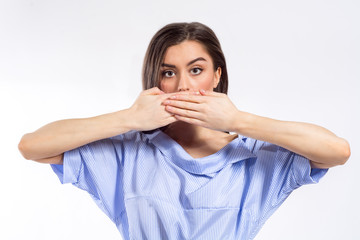 Closeup portrait of a young woman covering her mouth with her both hands. No freedom of speech, silence, concealment concept