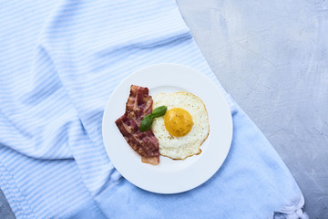 tastu fried egg in plate with bacon
