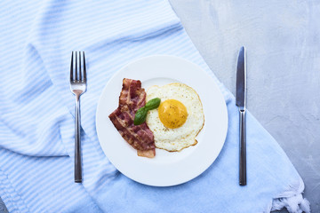 tastu fried egg in plate with bacon