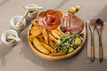 Meat snacks on a wooden plate flatlay