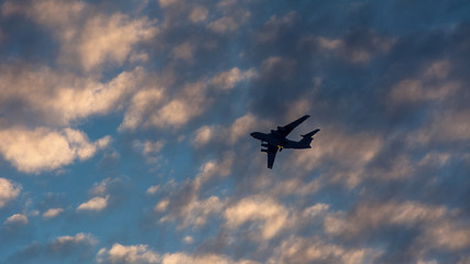 Fototapeta na wymiar Silhouette of the plane in the clouds at sunset
