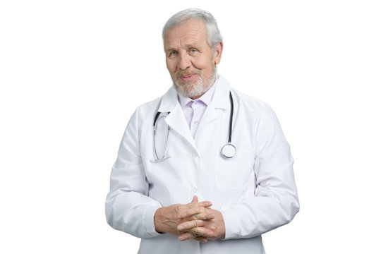 Senior old doctor with folded hands portrait. Physician with stethoscope. White isolated background.