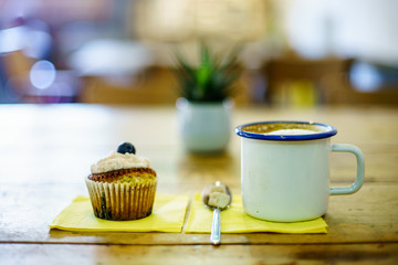 Coffee Cappuccino and Blueberry muffin on wooden table. 