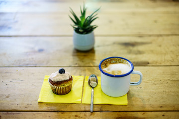 Coffee Cappuccino and Blueberry muffin on wooden table. 