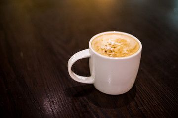 Coffee Lattee on the wooden table with back light