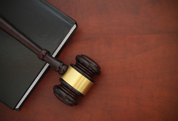 Gavel and legal book on wooden table