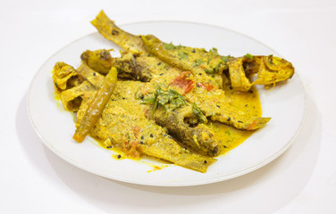 Spicy Parshe fish masala curry garnished with coriander and green chili. Parshe fish is a popular non vegetarian diet in West Bengal, India. Photograph shot in selective focus.