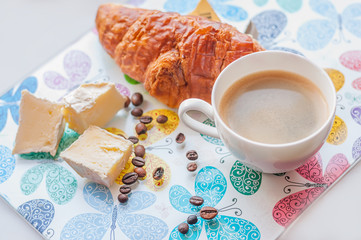 Coffee, croissant, cheese on a light colorful motley tray. light photo
