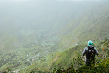 Fototapeta na wymiar Cape Verde. Calm moment. Tourist with backpack is overlooking the valley. Rural landscape with mountain ridge on the path to the Xo-Xo Valley. Santo Antao Island