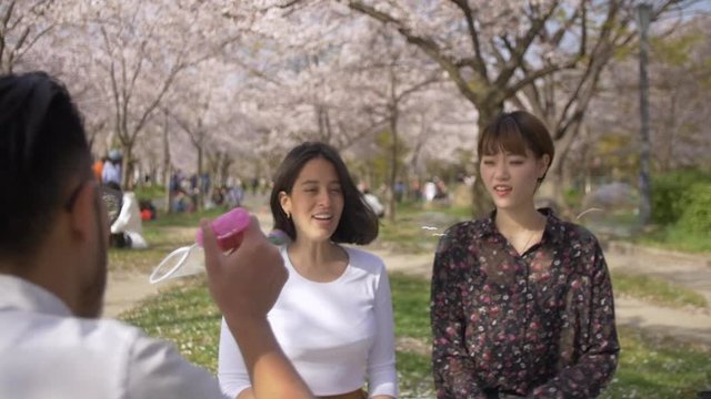 Friends having fun at cherry blossom picnic.