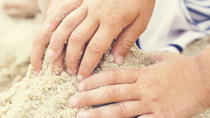 Group of little children build a sand tower, hands closeup