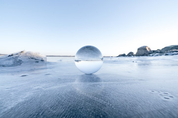 Elegant glass orb on ice on a frozen lake
