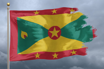 Grenada Flag with torn edges in front of a stormy sky