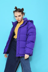 Young fashion woman in short violet down jacket.