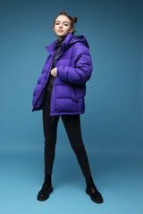 Young fashion woman in short violet down jacket and leather boots
