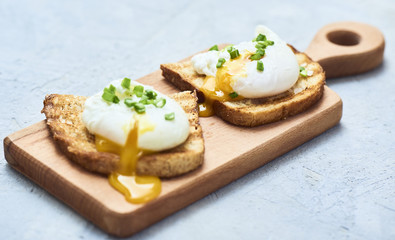 Tasty poached egg on toast over rustic background