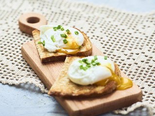 Tasty poached egg on toast over rustic background