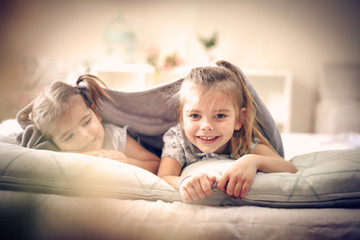 Two cheerfully little girls in bed.