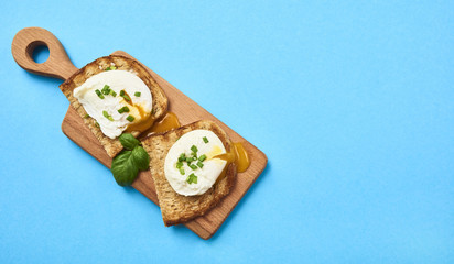 Tasty poached egg on toast over rustic background