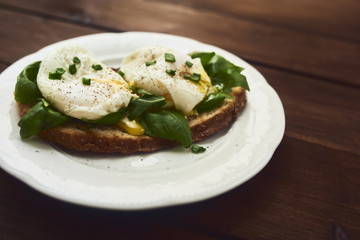 Tasty poached egg on toast over rustic background