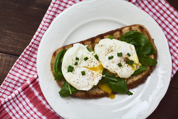 Tasty poached egg on toast over rustic background