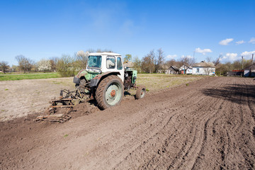 The tractor plows the earth