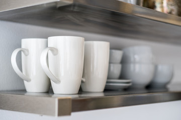 Ceramic bowls and mugs on shelf