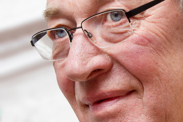 Nahaufnahme des Gesichts eines älteren Mannes mit skeptischem Blick