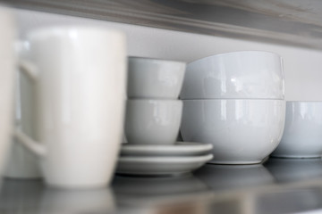 Ceramic bowls and mugs on shelf