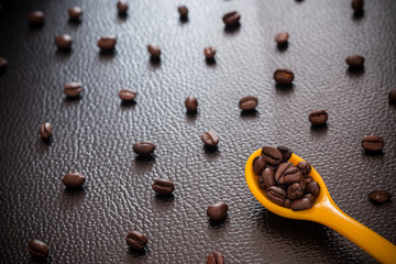 Fototapeta na wymiar concept Coffee beans on Animal skin a dark background yellow spoon