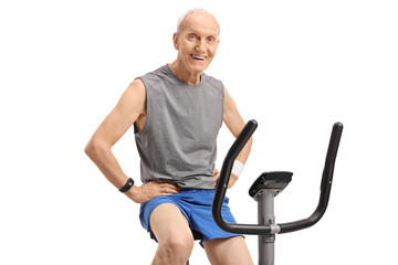 Senior on an exercise bike looking at the camera and smiling