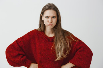 Childish girlfriend wants attention. Portrait of displeased offended european woman in red loose...