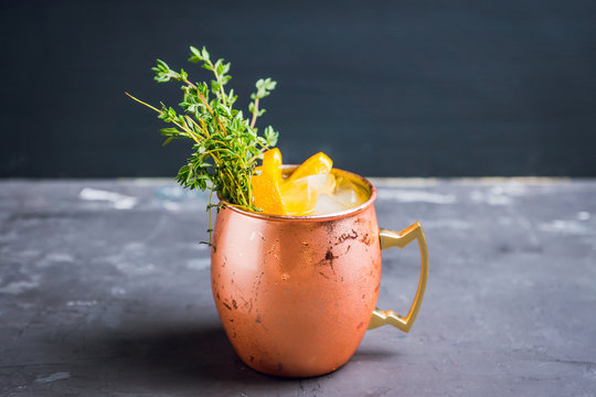 Cold orange Moscow mule cocktail in copper mug. Selective focus.
