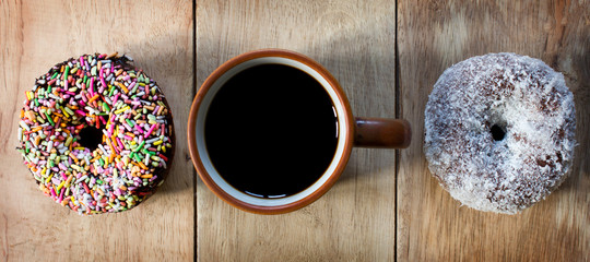 Black coffee and Donuts on wooden background, Coffee break, Free space for text, Top view.